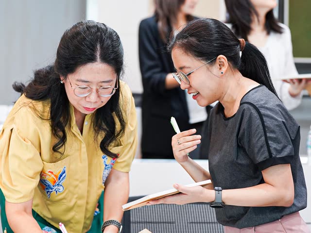 ผู้เข้าร่วมยืนเขียนลงกระดาษระหว่างกิจกรรม